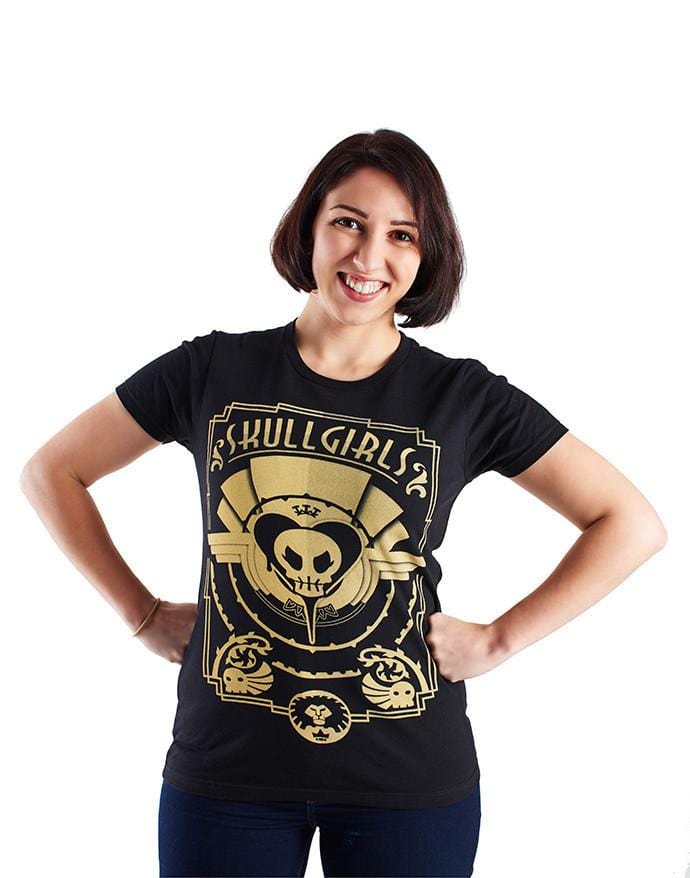 The Skullgirls Deco shirt is black, with an art deco design across the front. The title "Skullgirls" adorns the top of the design. In this image, it is worn by a model.