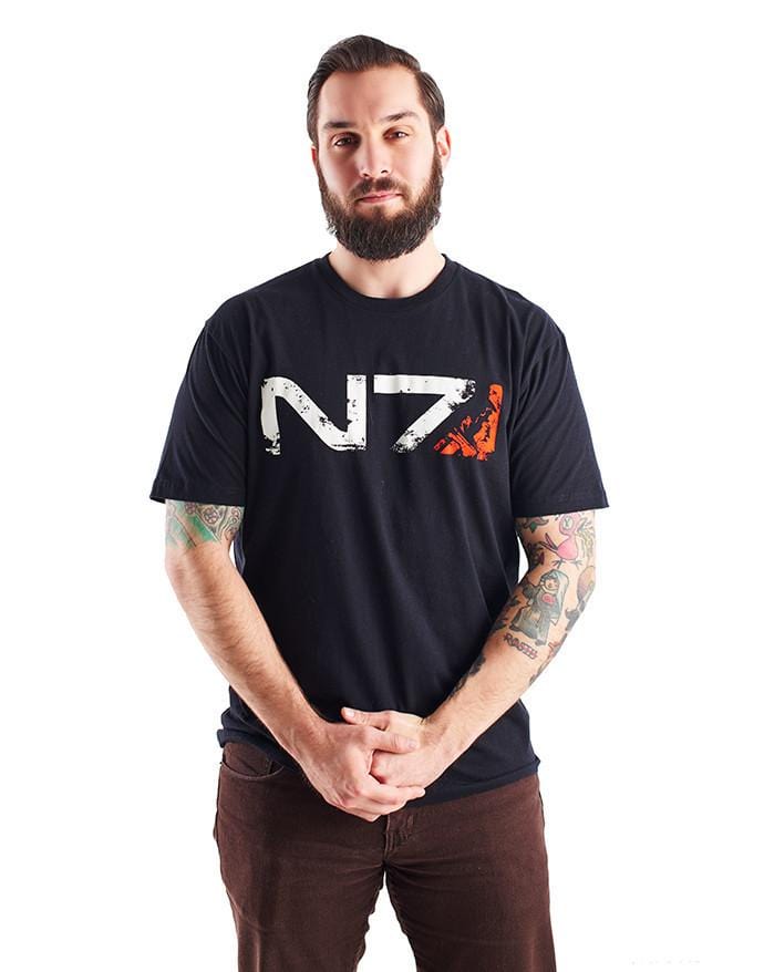 An image of the N7 Commander M-Shep Shirt. It is a black shirt with the N7 logo across the front in weathered-looking print, with m-Shep's face silhouetted in the red portion at the end.