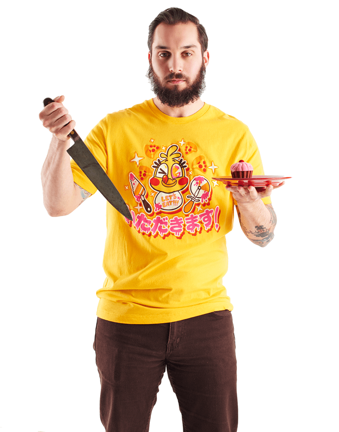 An image of the Chicadakimasu shirt, worn by a model holding a knife and a cupcake on a plate.