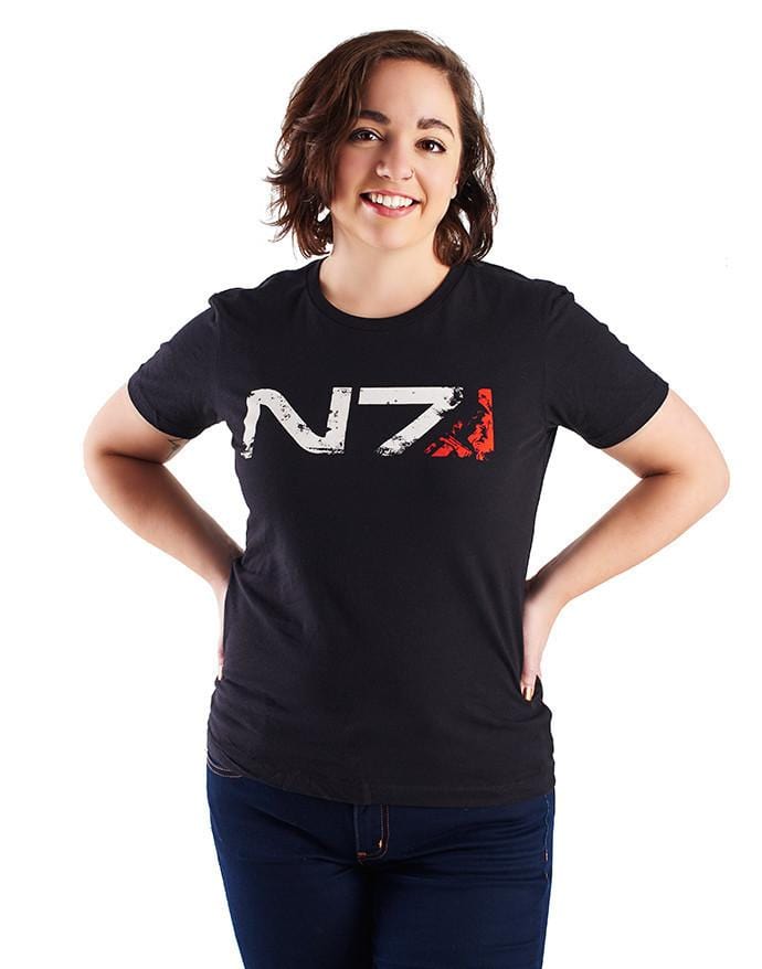 An image of the N7 Commander M-Shep Shirt. It is a black shirt with the N7 logo across the front in weathered-looking print, with m-Shep's face silhouetted in the red portion at the end.