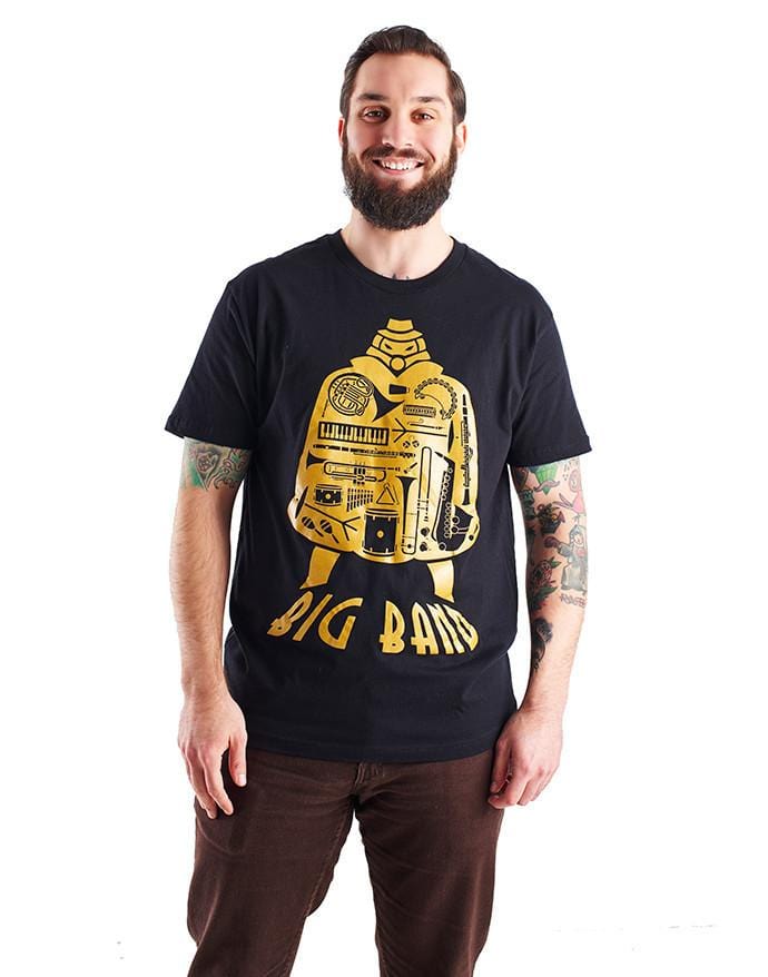 Image of the Big Band shirt, which features the SG character, his silhouette filled with the images of various musical images, and the name "Big Band" along the bottom of his image. It is shown being worn by a smiling model with a beard.
